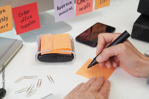 closeup of a man writing a note in an office desk