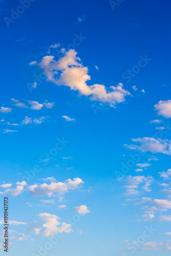 vertical blue sky with white soft clouds. clear atmosphere for summer weather background. peaceful nature on a sunny morning. scenic outdoor pattern for meteorology or idyllic holiday aesthetic