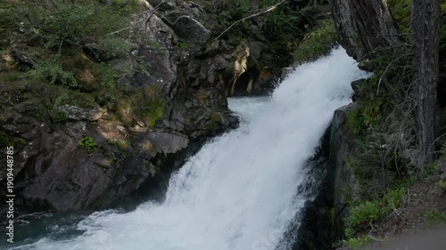 Natural landscape of Stuibenfall waterfall in Austria where clear mountain river drops through rocks surrounded by pine forest and alpine scenery