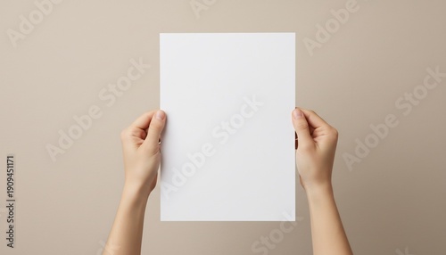 Person holding blank white sheet of paper against beige background, mockup
