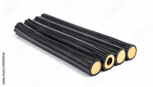Black licorice candy sticks with cream filling on white background.