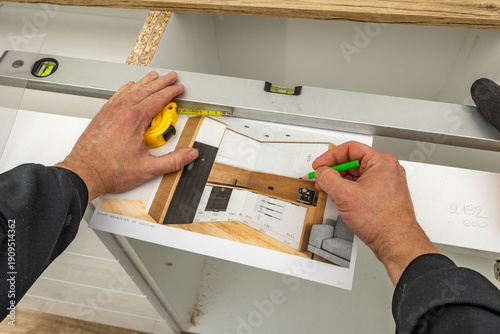 Fotografía A carpenter makes corrections to a kitchen furniture design, a man draws a kitch