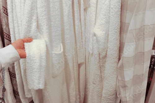 Photography White terrycloth robes on a hanger in a store
