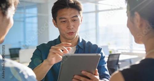 Business professionals collaborate over tablet in modern office setting
