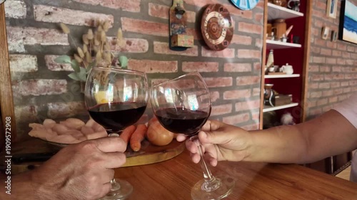 Senior couple toasting with red wine glasses in the kitchen