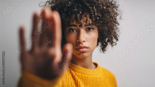 Serious young woman showing stop gesture with hand. Concept of boundaries, protection, self respect and women empowerment.