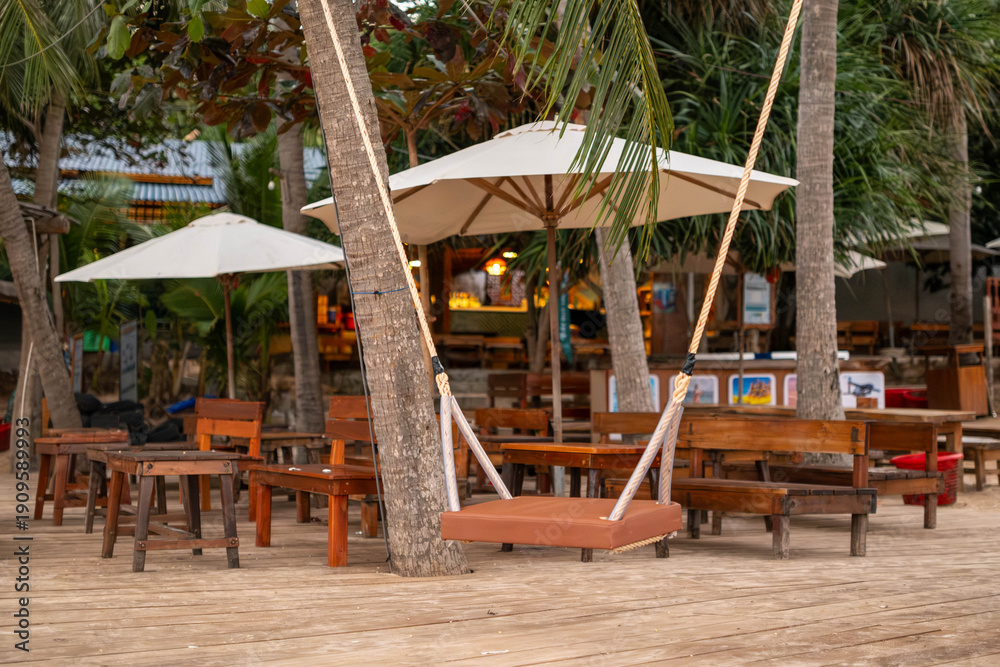 Naklejka premium Tropical Beach Bar with Wooden Swing and Umbrellas in Phu Quoc