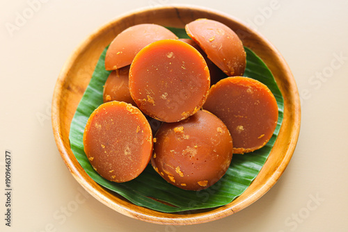 Obraz na plátně Overhead of round blocks of traditional Indonesian palm sugar in a wooden bowl