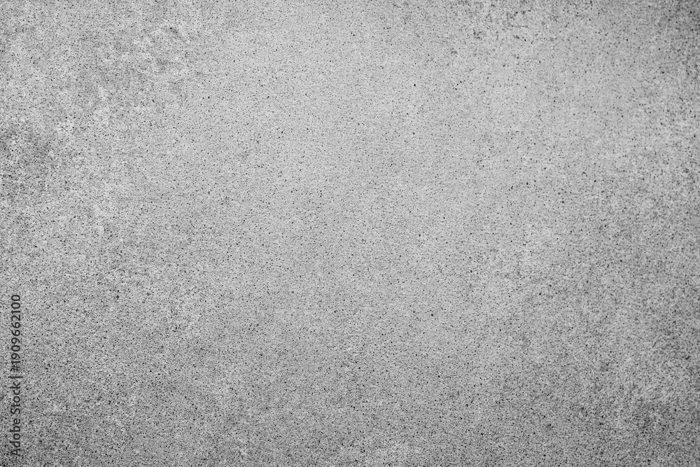 Fototapeta premium Rough gray speckled concrete surface textured background showing many small dark particles evenly spread