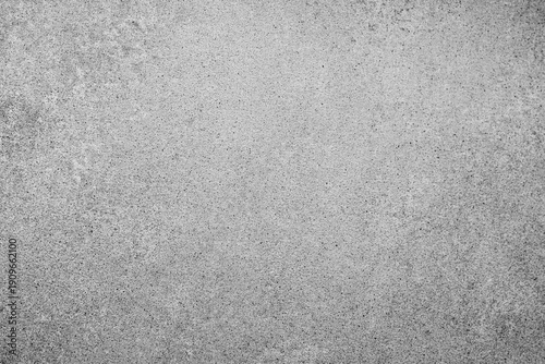 Rough gray speckled concrete surface textured background showing many small dark particles evenly spread