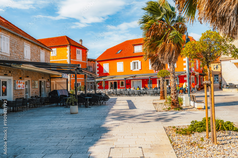 Fototapeta premium Jelsa town on Hvar island, with traditional Dalmatian stone architecture and boats moored in the harbor, Croatia.