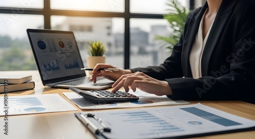 A professional working on financial analysis, using calculator and laptop