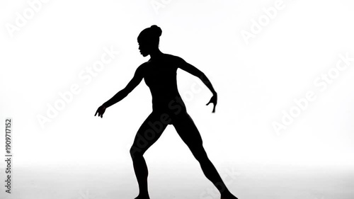 Silhouette of a dancer in motion against a bright white background (1)