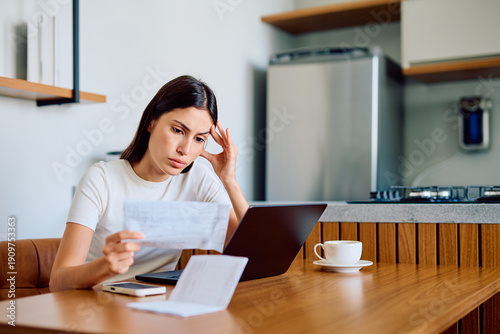 Quadro su tela Woman feeling stressed and anxious while looking at documents and tracking expen