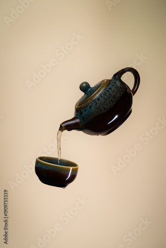 Pouring Tea from Teapot into Small Cup