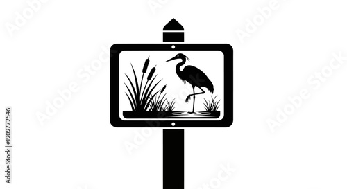 Black and white silhouette of a heron standing in water with reeds, depicted on a signpost, symbolizing a wildlife or nature reserve area.