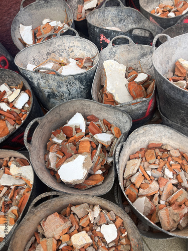 A collection of construction buckets filled with rubble. Brick fragments from a building undergoing demolition.