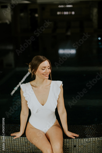 Woman in white swimsuit sit...