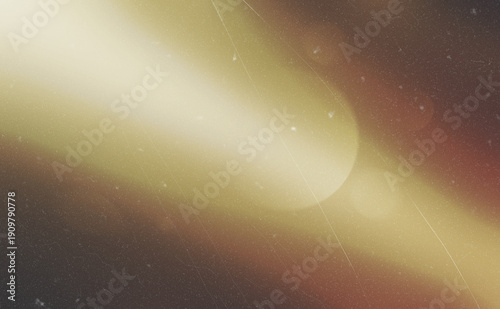Abstract golden light beam with vintage film grain and lens flare effect on dark backdrop.