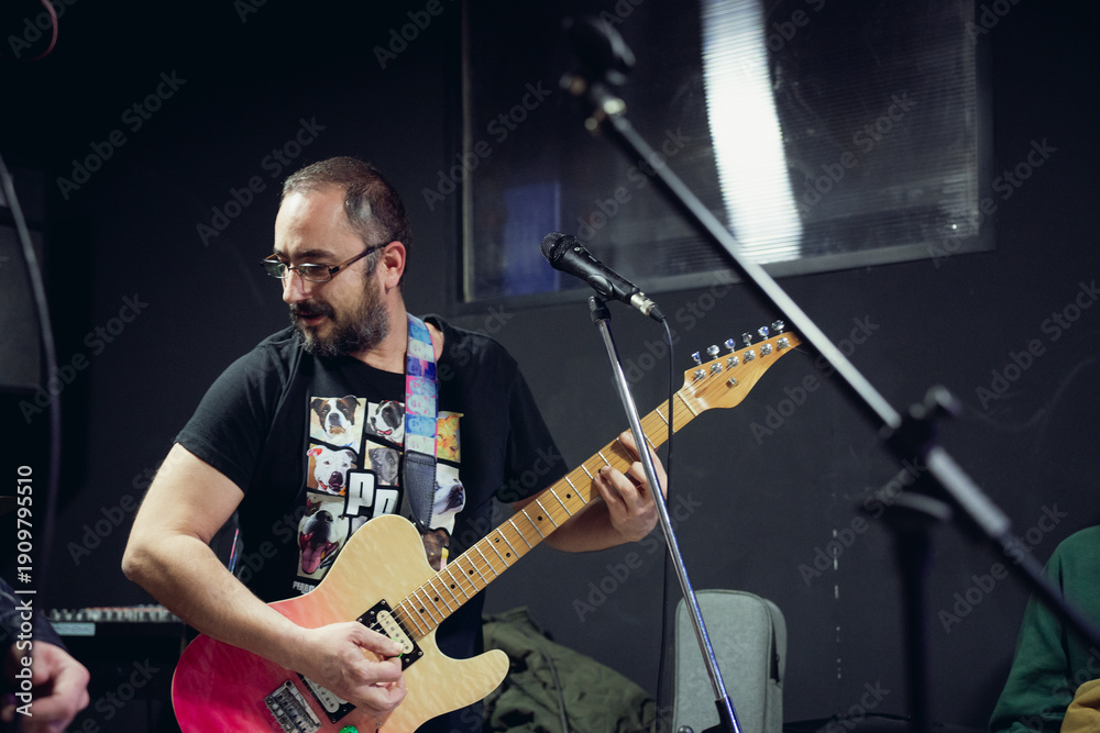 Obraz premium Musician playing electric guitar during band rehearsal