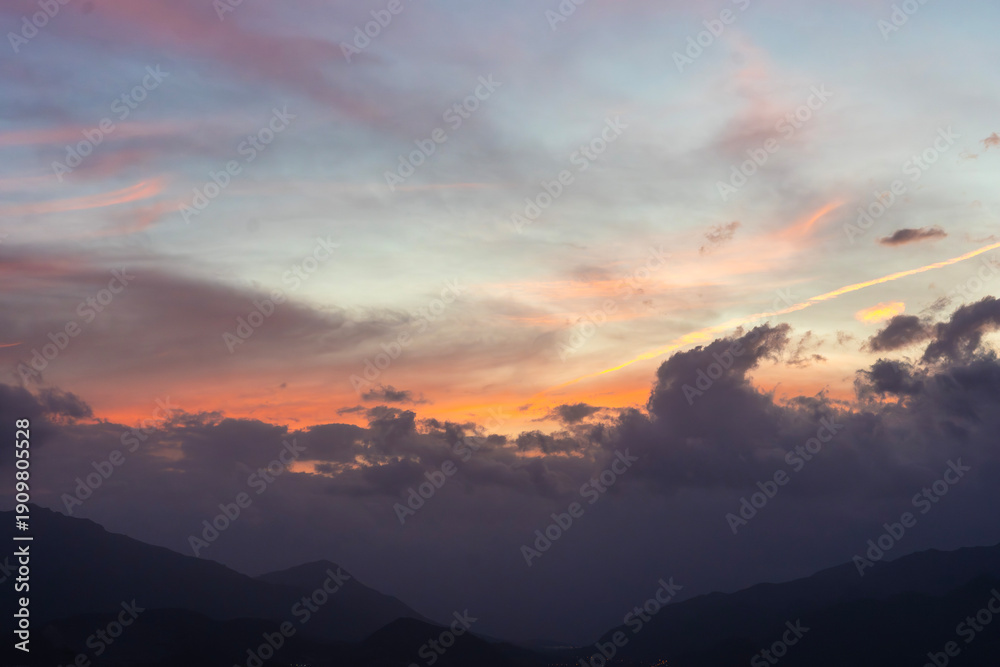 Fototapeta premium Bright sunset over the silhouette mountains at evening time.