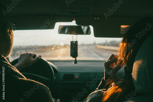 View from the back seat of the car at the couple and the highway
