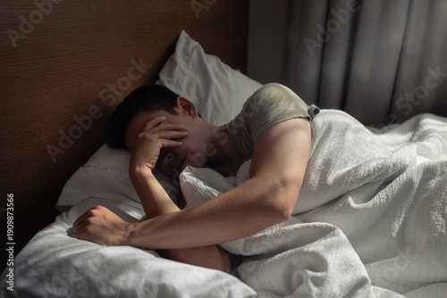 Slika na platnu Exhausted Man Covering Face in Bed – Anxiety, Burnout and Sleepless Night