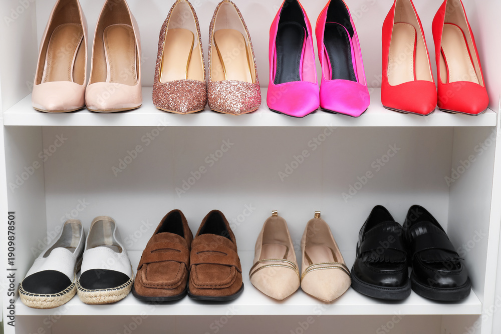 Fototapeta premium Shoe storage. Shelving unit with different footwear indoors, closeup
