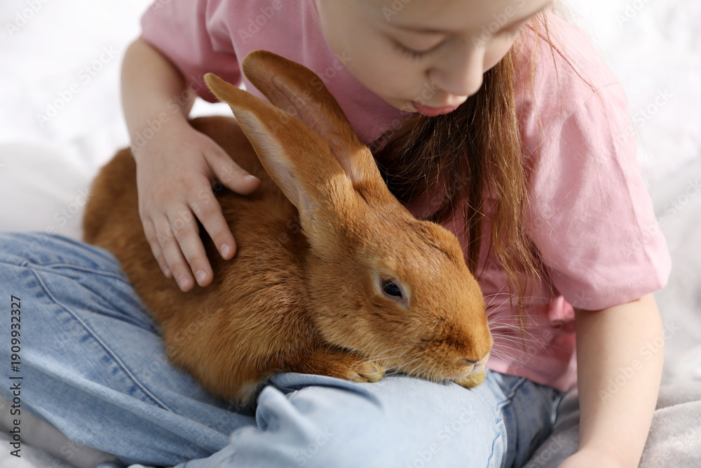 © New Africa - Girl with cute bunny at home, closeup