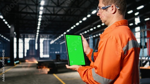 Photography Vertical green screen with worker managing steel operation tasks, surrounded by metal machinery and fabrication tools within the warehouse facility