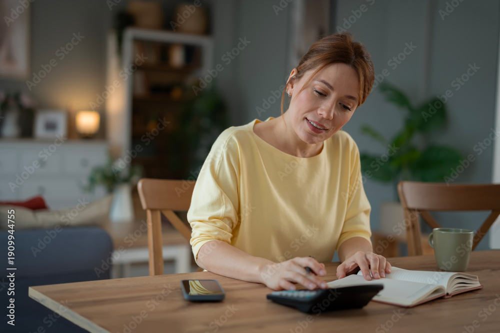 Obraz premium Woman calculating home budget managing personal finances