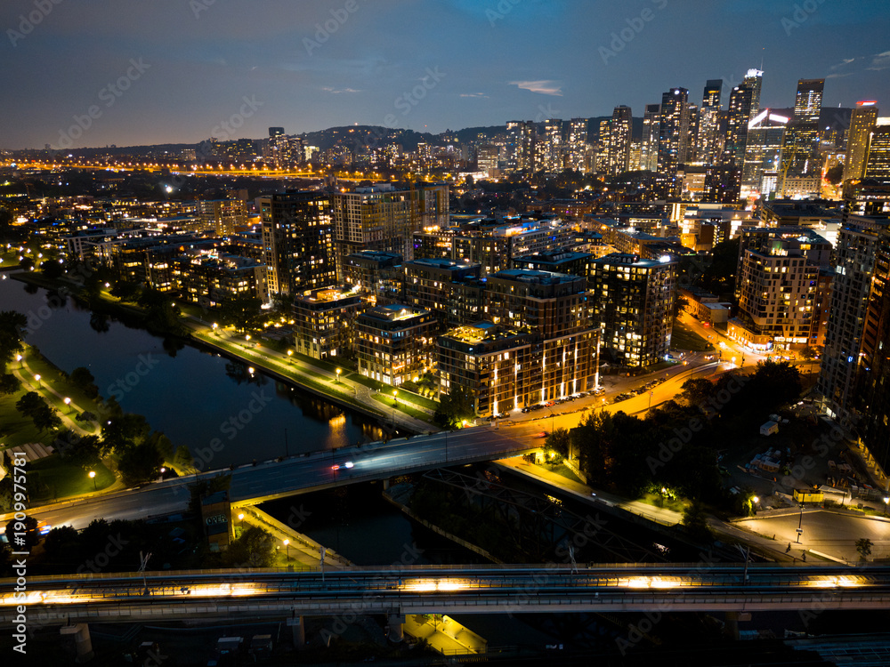 Fototapeta premium Montreal skyline illuminated at dusk and reflected in the water, Quebec, Canada.