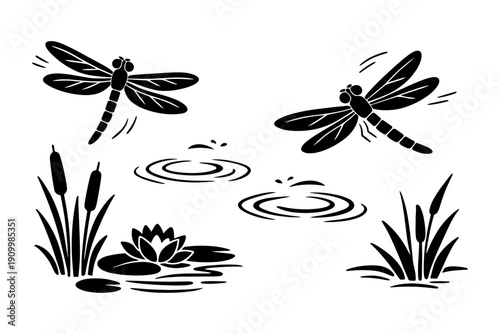 Silhouette of dragonflies over water with lily pad and cattails