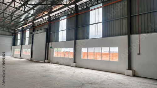 Foto Modern empty warehouse, factory with spacious concrete floor and high ceiling
