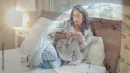 Woman sitting bed lifting mug and sipping while clock and globe overlaying tracking morning health