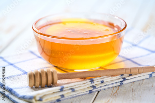 Wallpaper Mural Glass bowl with sweet honey on а white table, selective focus. Torontodigital.ca