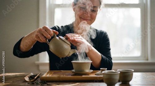 Young Woman Pouring Hot Tea from Traditional Teapot into a Cup, Enjoying Relaxing Moment at Home, Wellness and Mindfulness Practice, Cozy Lifestyle with Soft Natural Light