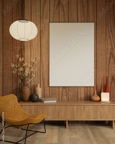 White frame and round lamp on wooden wall over table an yellow fabric accent chair on parquet floor.