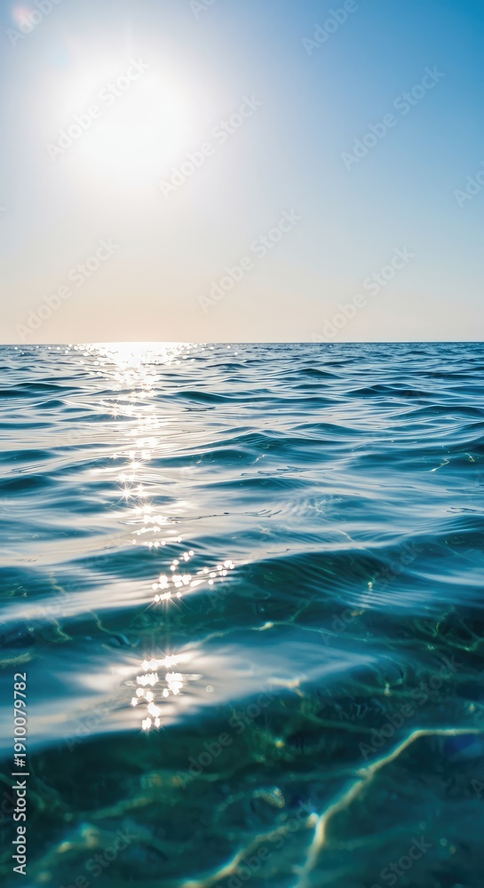 Obraz premium A bright sun illuminates clear blue water with gentle waves creating shimmering patterns perfect for a refreshing summer day at the beach ,refreshment ,daytime ,tranquil