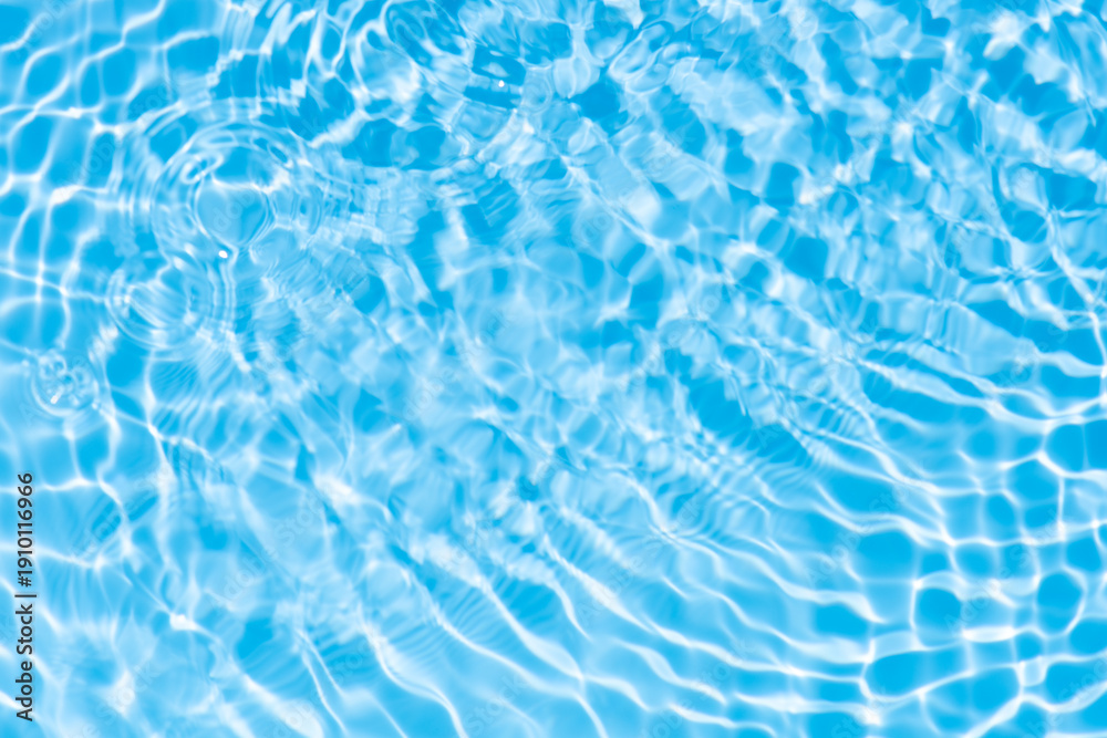 Obraz premium Blue water with ripples on the surface. Defocus blurred transparent blue colored clear calm water surface texture with splashes and bubbles. Water waves with shining pattern texture background.