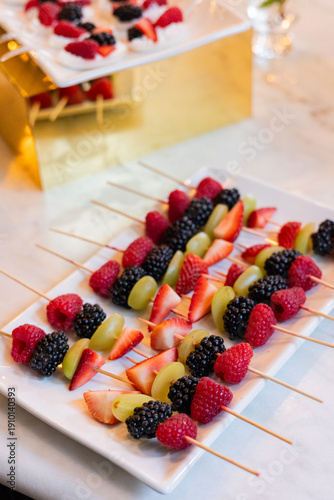 Billede på lærred wooden fruit skewers being served on white platter at brunch event