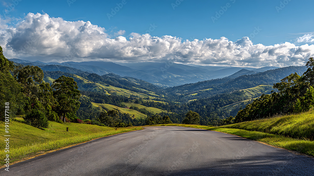 Fototapeta premium Scenic Valley Road with Rolling Green Hills and Clouds