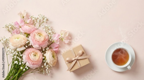 A serene still life arrangement featuring flowers, gift, and tea on a soft pastel background from a top-down viewpoint.