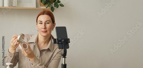 Woman vlogging and reviewing cosmetic product online