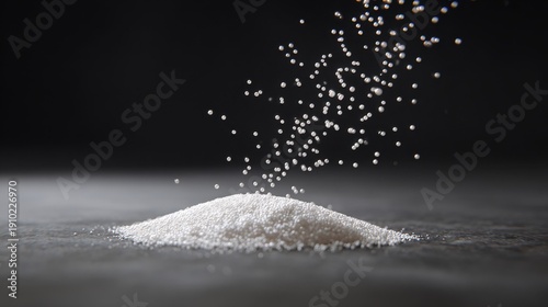 Sugar Pouring: A close-up shot of granulated sugar cascading onto a small heap, showcasing texture.