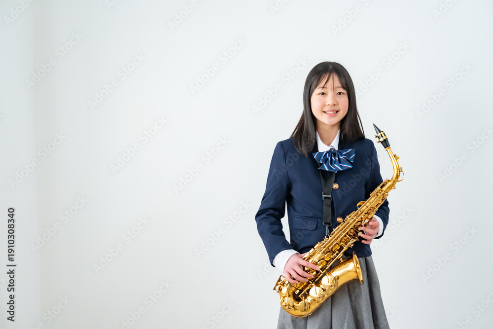 Fototapeta premium アルトサックスを持って笑顔の制服姿の日本人少女