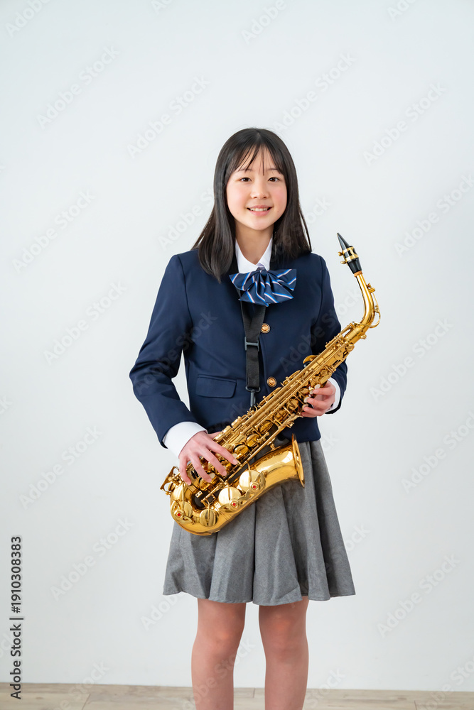 Fototapeta premium アルトサックスを持って笑顔の制服姿の日本人少女