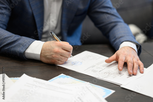 Man signing official contract with stamp on document