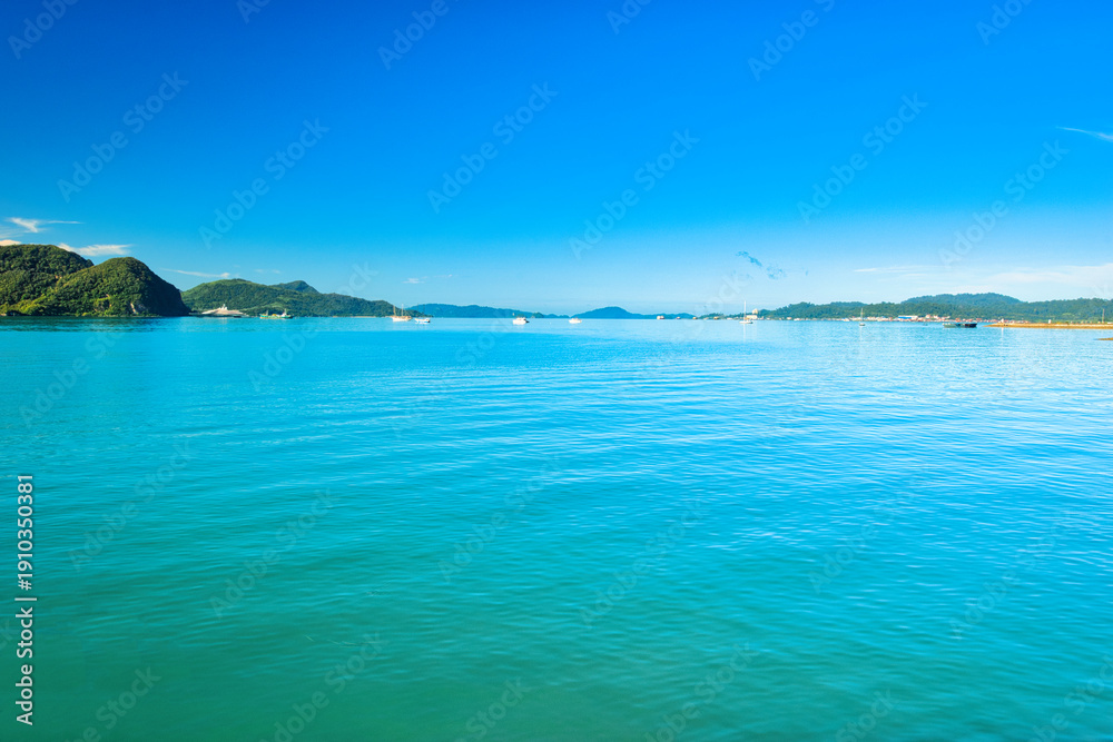 Obraz premium A beautiful view of Langkawi island against a beautiful blue sky with some boats in the distance on the horizon. Tropical scenery. located at Kedah, Malaysia - September 25 2024: