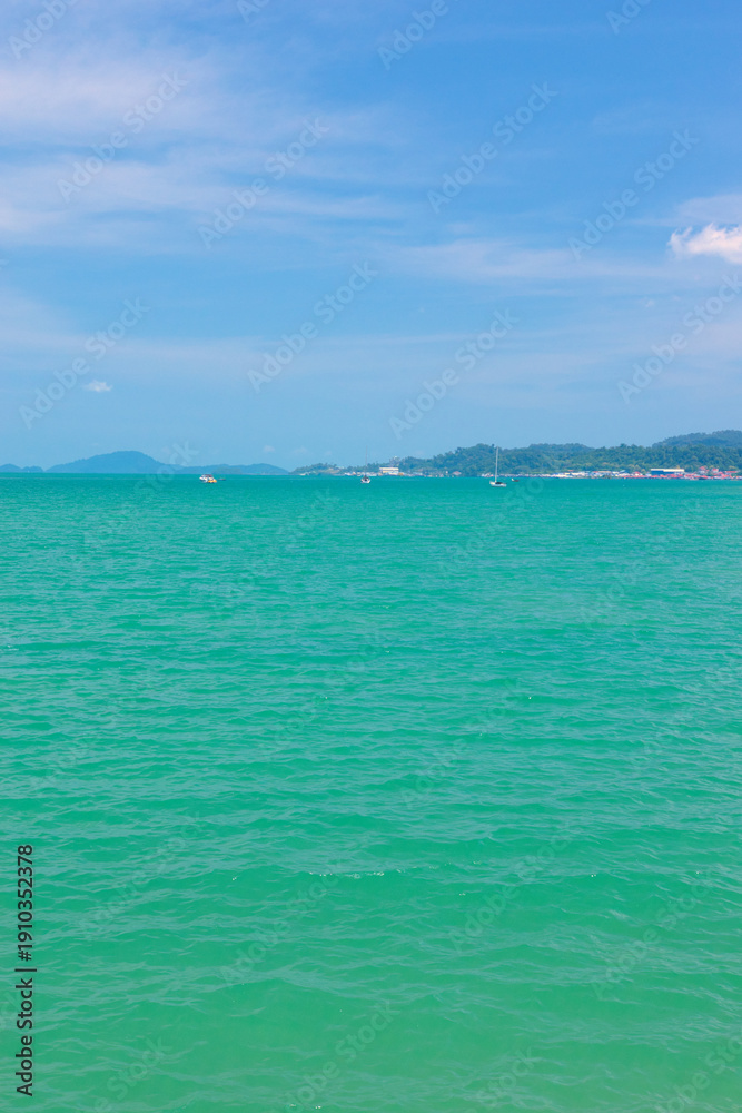 Obraz premium A beautiful view of Langkawi island against a beautiful blue sky with some boats in the distance on the horizon. Tropical scenery. located at Kedah, Malaysia - September 25 2024:
